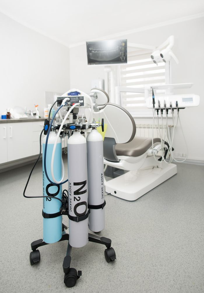 services-01 Bright dental clinic room featuring cutting-edge equipment and medical gas tanks for professional use.